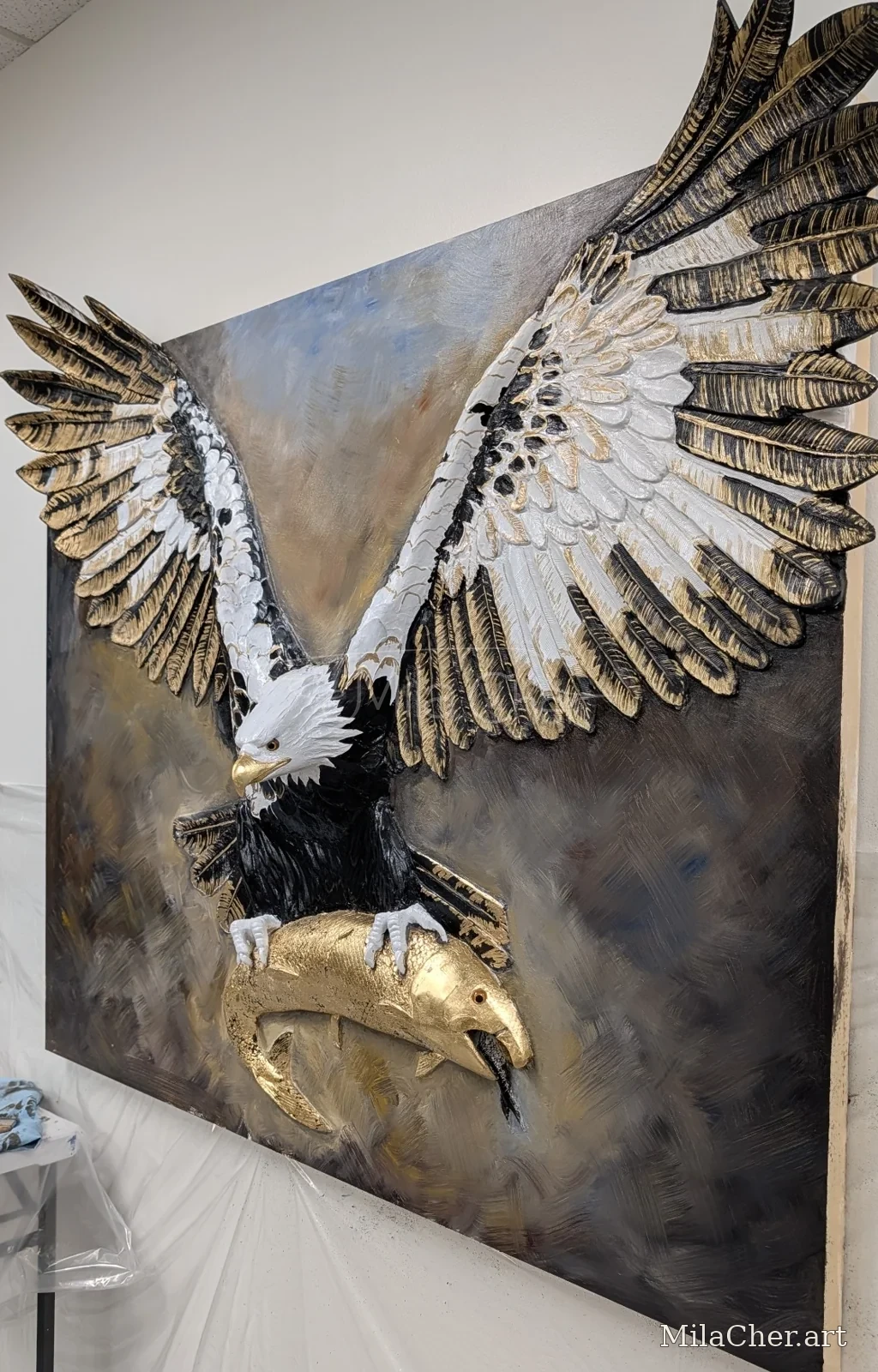 Large dimensional eagle with wings extending beyond the canvas, holding a gold fish