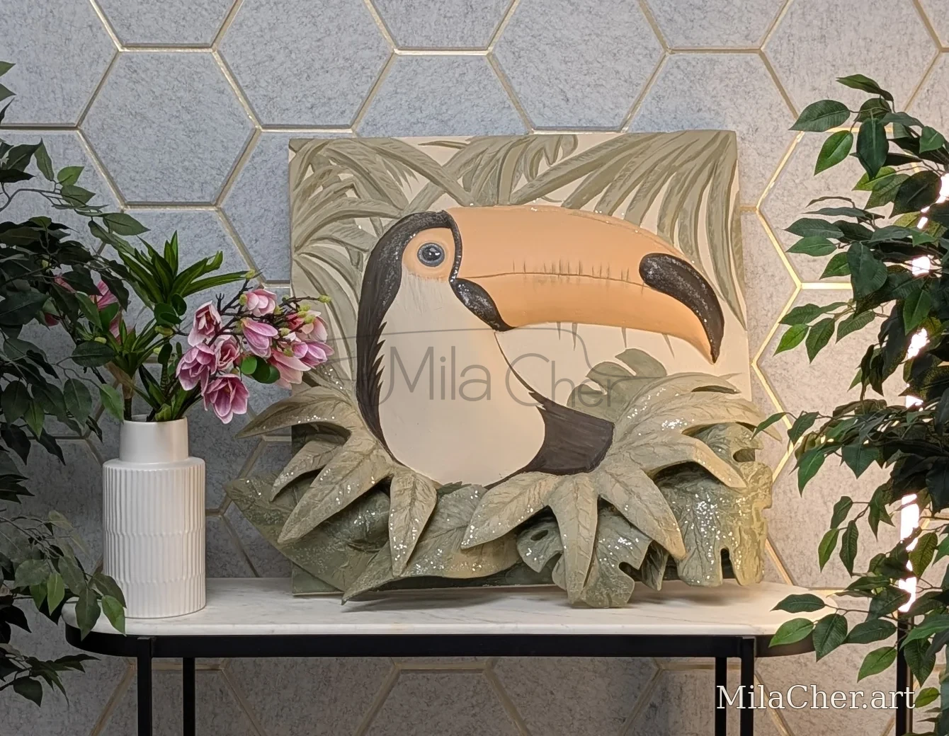 Toucan artwork with sculpted foliage in a room setting